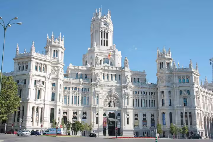Ornate white facade of Palacio de Cibeles in Madrid under clear blue sky