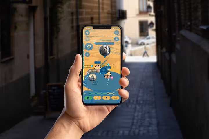 Hand holding smartphone with self-guided Madrid Golden Age walking tour app map in historic narrow alley