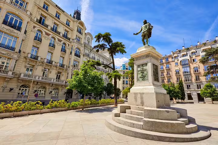 Historic plaza with bronze statue and elegant Belle Époque buildings in Madrid city center