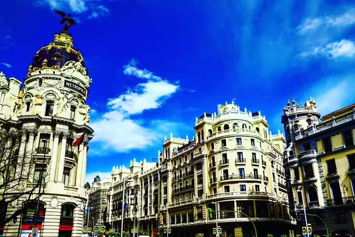 Metropolis Building and grand historic architecture along Gran Vía street in Madrid, Spain under blue sky