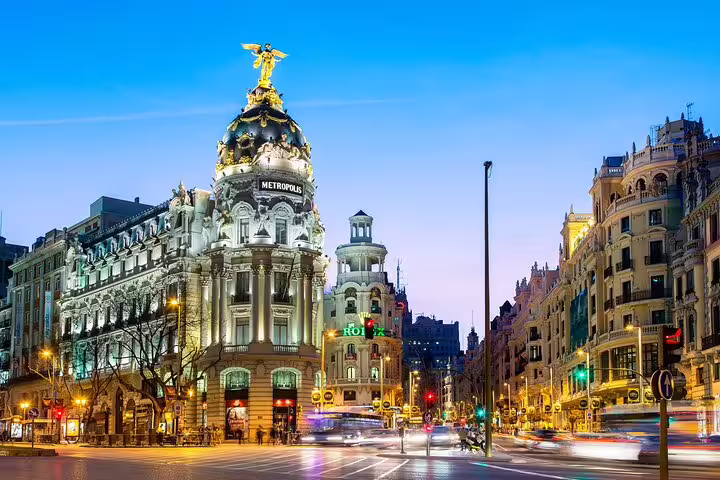Metropolis Building illuminated at dusk on Gran Via, Madrid city center with light trails