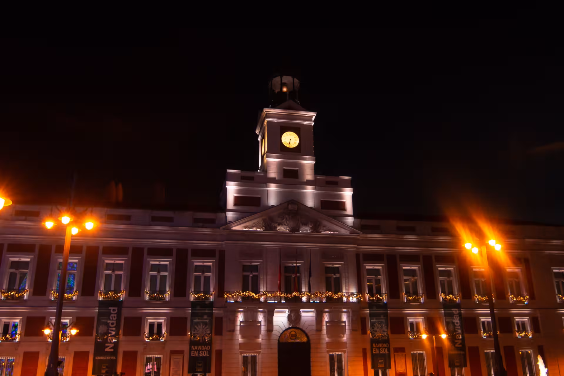 Night view of Real Casa de Correos at Puerta del Sol, a landmark on the Madrid Misterios Locales tour route