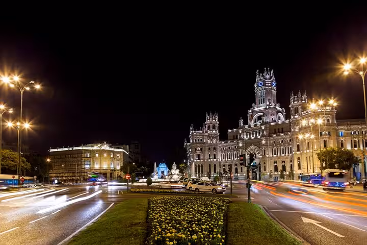 Madrid city center at night with illuminated Cibeles Palace and light trails from passing cars