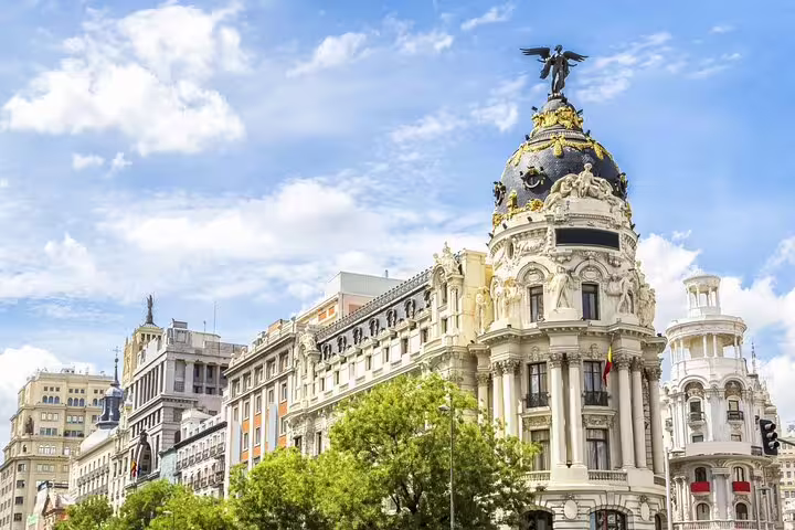 Ornate Metropolis Building facade on Gran Via street in Madrid city center under blue sky