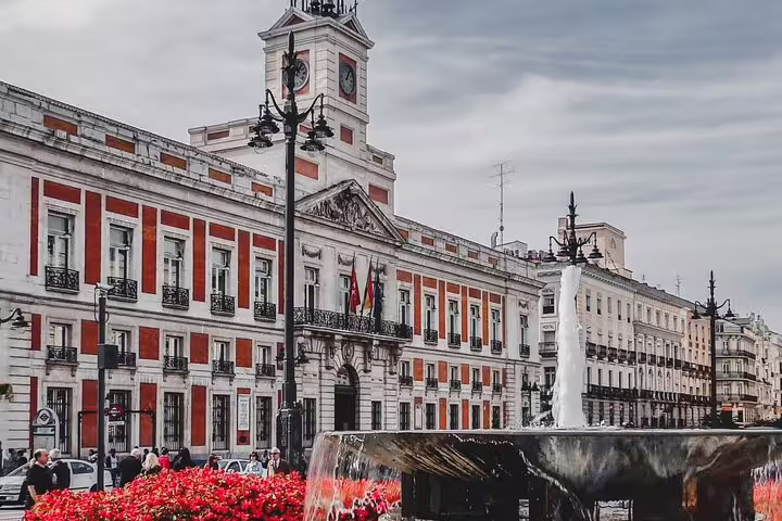 Puerta del Sol square with fountain and historic red-and-white building in Madrid city center