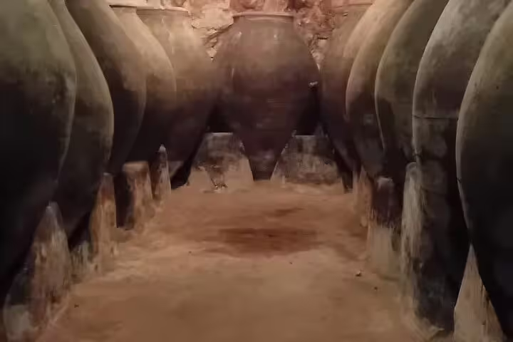 Explore historic wine amphorae in a rustic Chinchón cellar during the Madrid Wine Experience tour.