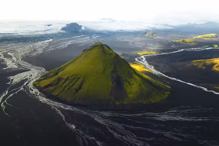 Aerial view of Mælifell green volcano cone surrounded by black lava fields in Iceland's Fjallabak highlands