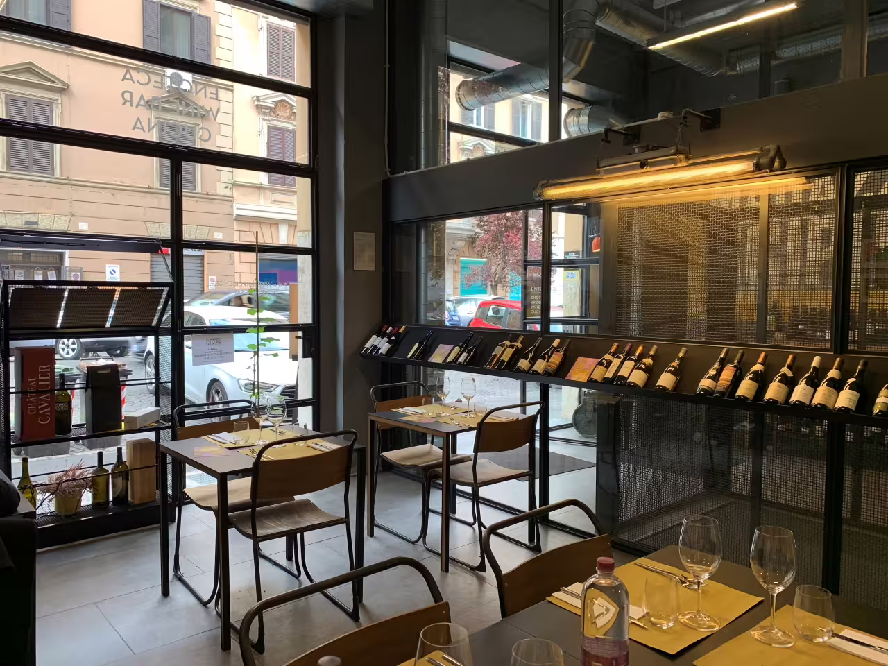 Magazzino Scipioni wine tasting room in Rome with bottle wall and tables set for elite gourmet experience