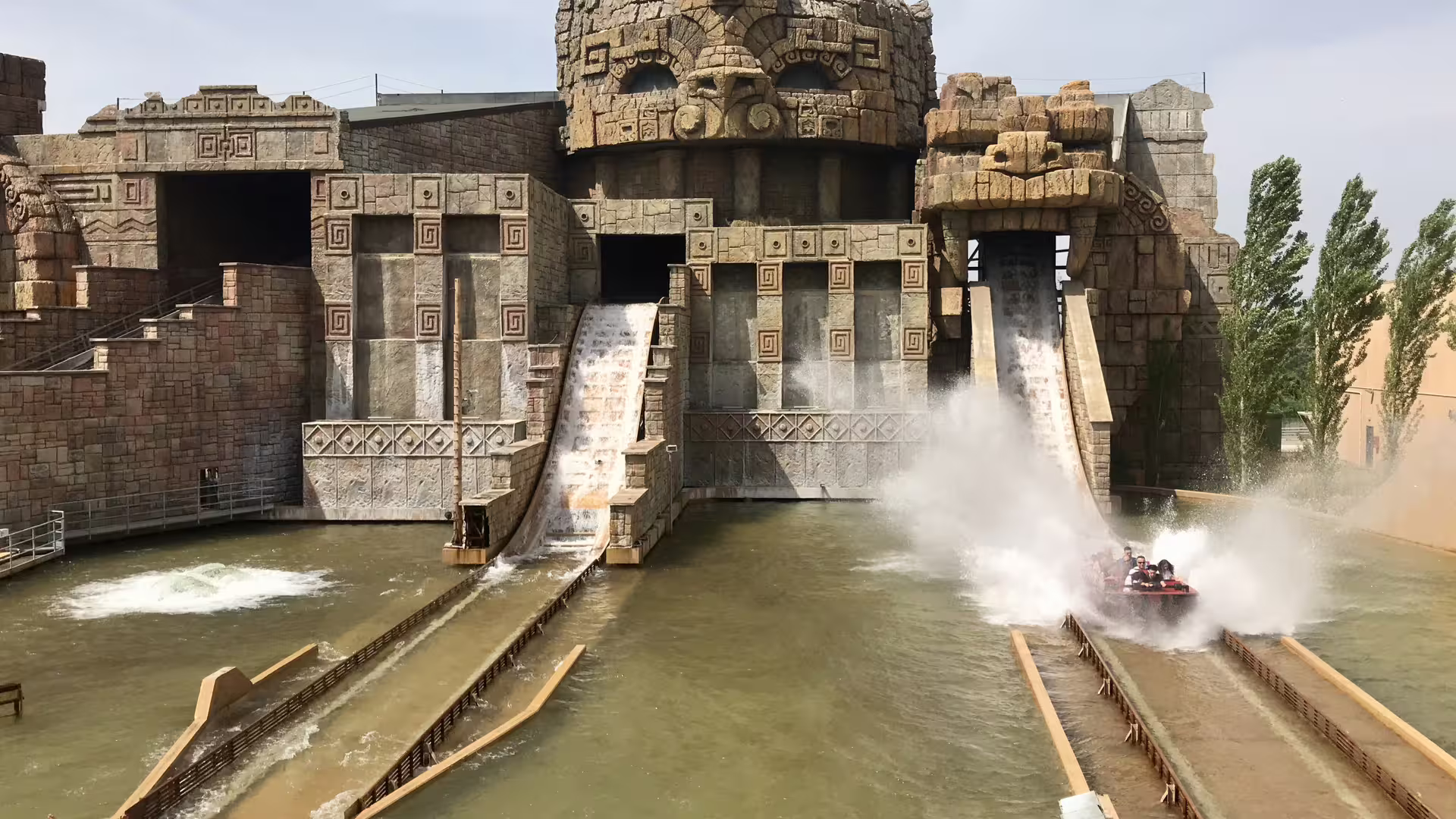 MagicLand amusement park water ride plunges from temple facade, creating huge splash on lake below