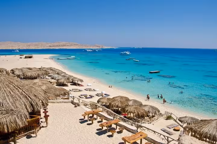 Mahmya Island beach from Hurghada with thatched huts, sunbeds and crystal Red Sea snorkeling lagoon
