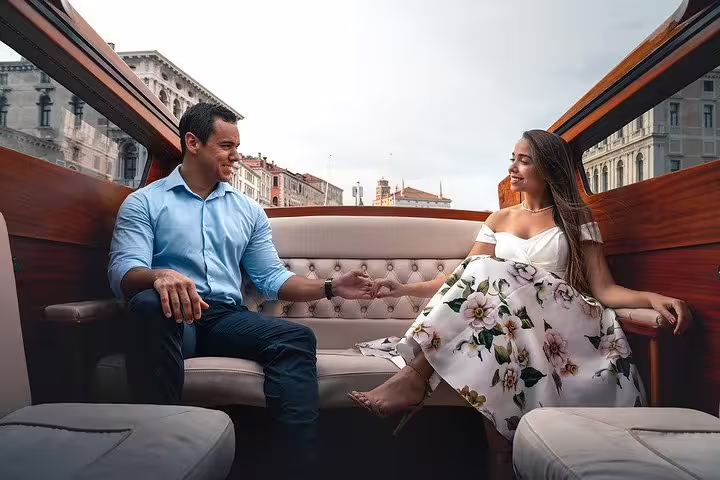 Couple enjoying a romantic moment on a luxurious mahogany boat tour with scenic city views.
