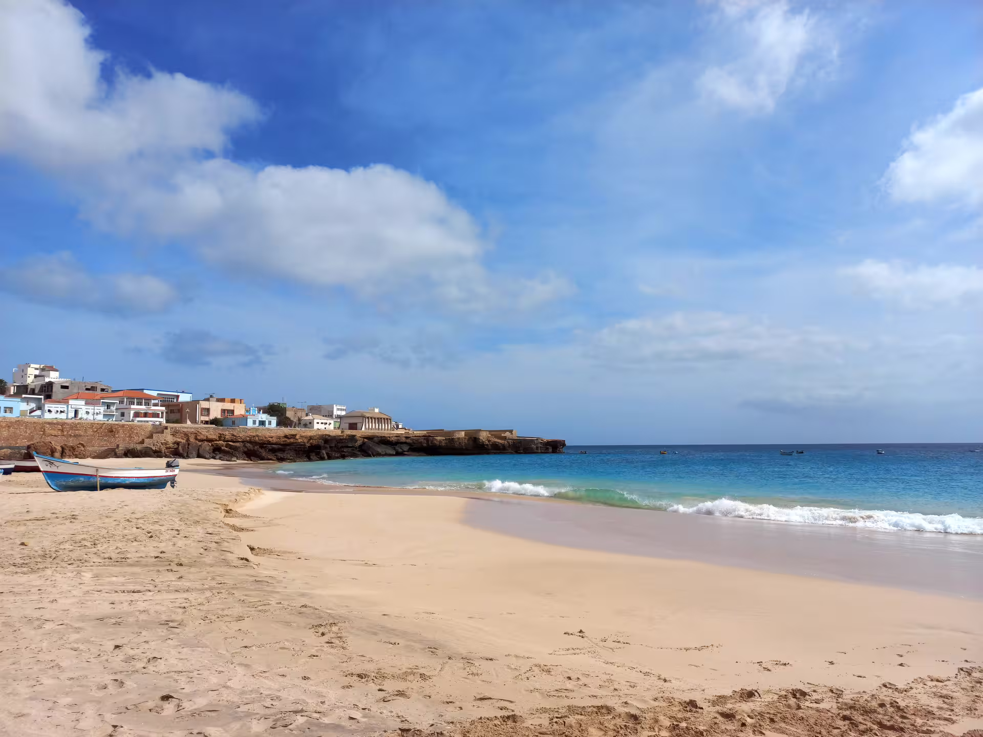 Peaceful beach scene with a boat on the sandy shores of Maio Island, showcasing the island's natural beauty.