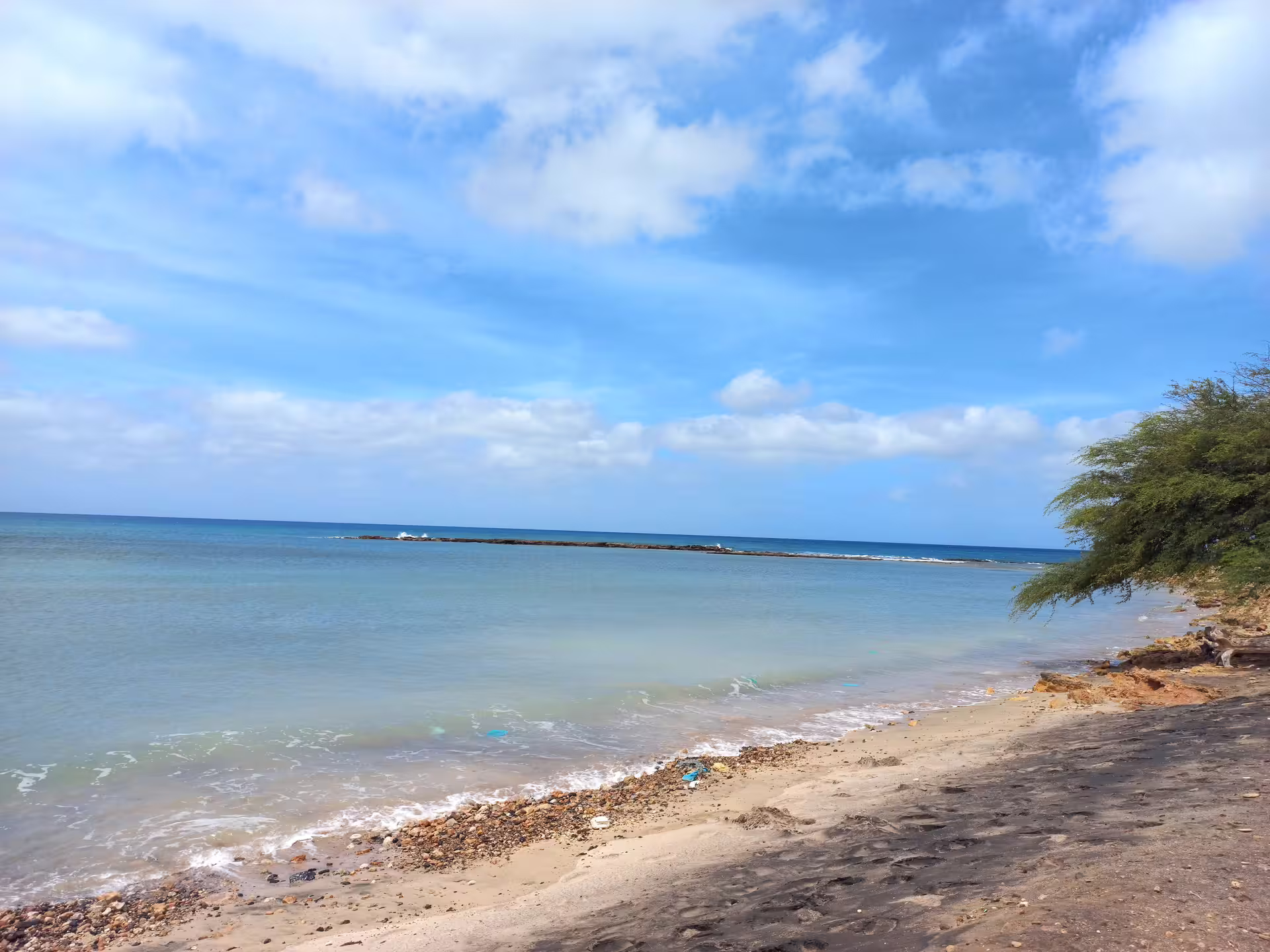 Tranquil beach with clear blue waters and a sandy shore on Maio Island, ideal for a full-day private tour experience.