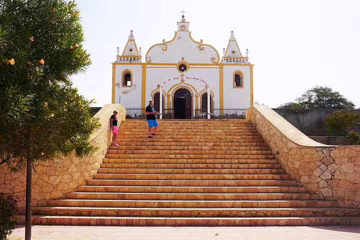 Visitors ascend the grand staircase to a historic church on Maio Island, showcasing cultural and architectural heritage.