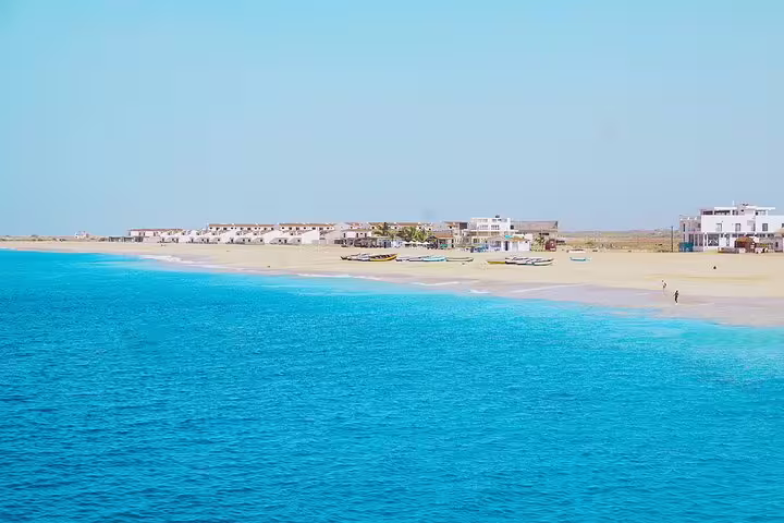 Scenic coastal view of Maio Island with sandy beaches, azure waters, and charming local architecture in the background.