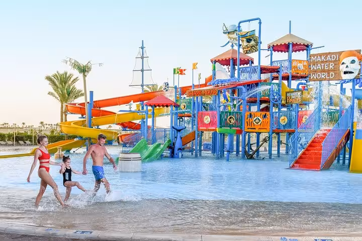 Family enjoying Makadi Water World splash zone and slides, Hurghada waterpark excursion with lunch and transfers