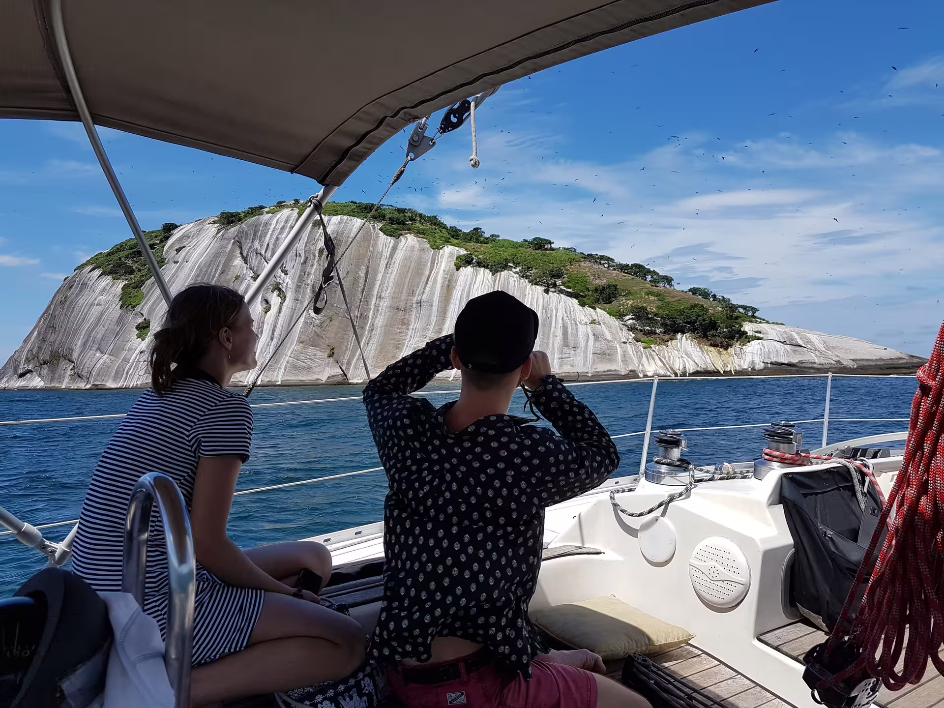 Scenic view of passengers enjoying island sights from a sailboat on the Makani Maikai private sailing tour.
