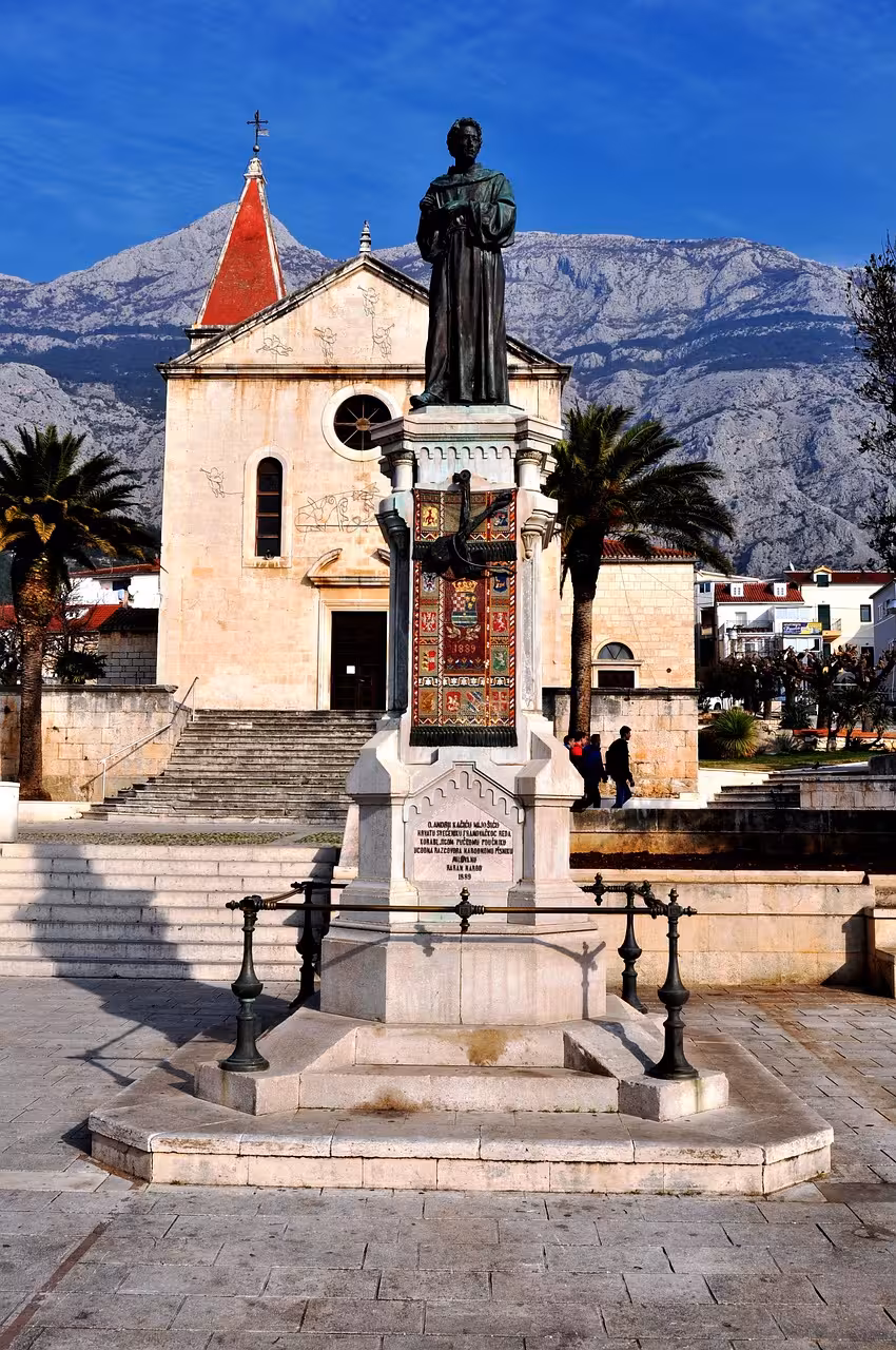 Makarska old town church and monument beneath Biokovo range, cultural photo stop on Split day tour