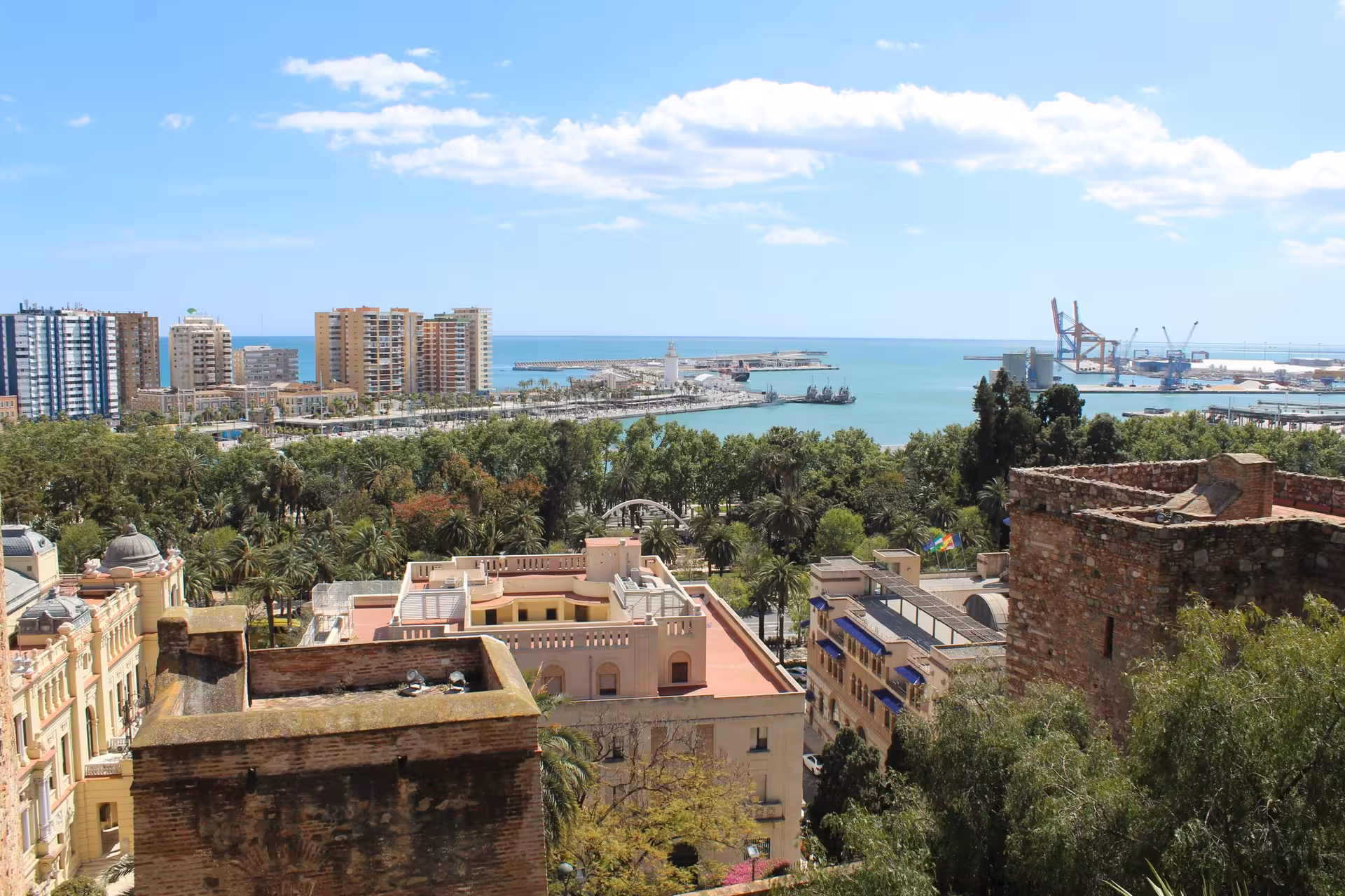 Panoramic view of Malaga's coastline and cityscape from the Alcazaba, showcasing the port and skyline.