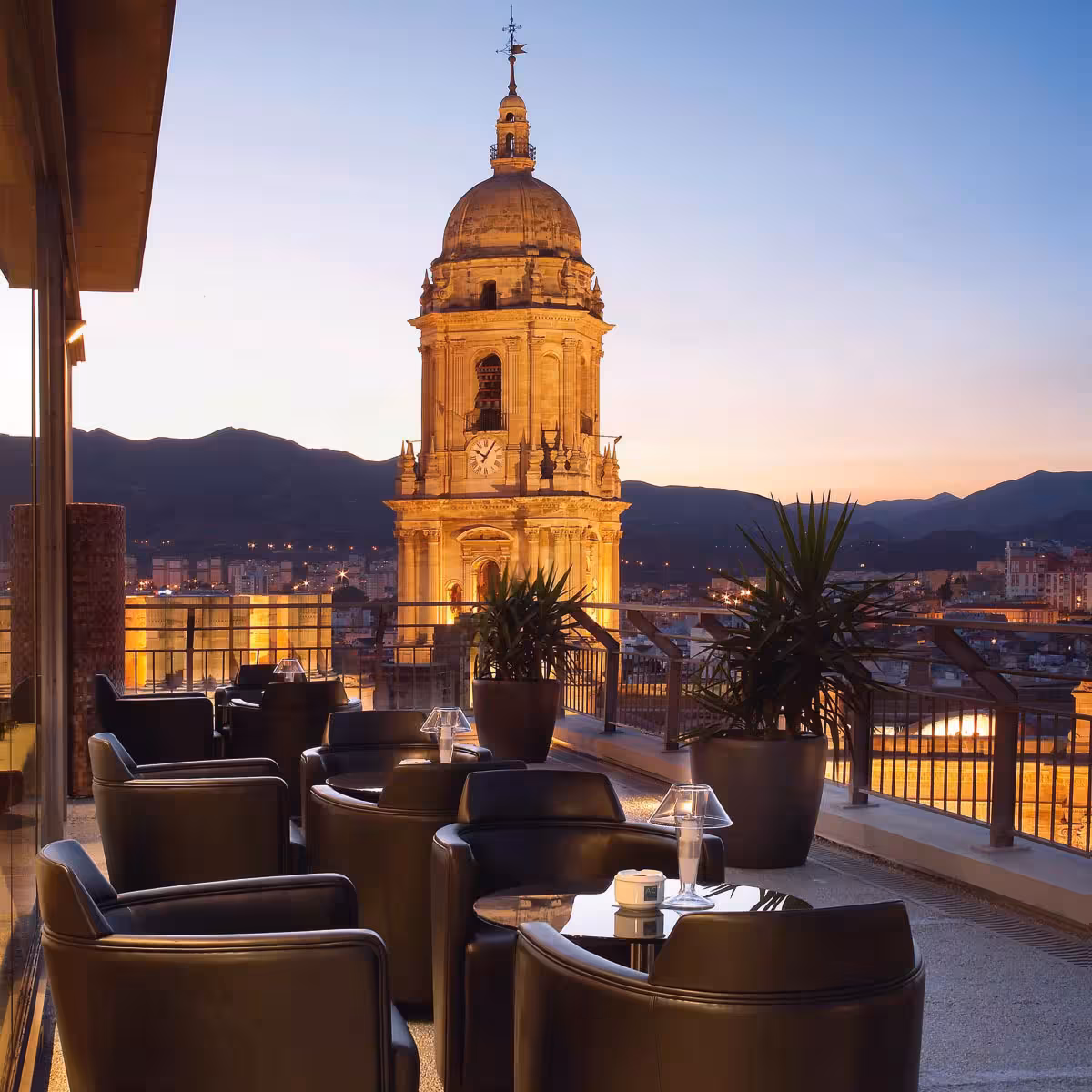 Stunning rooftop view of Malaga Cathedral at sunset, offering a luxurious setting and panoramic cityscape.