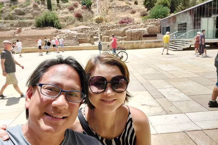 Couple taking selfie at Malaga historic Roman Theatre ruins during guided walking tour