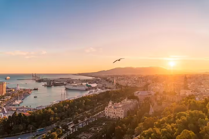 Breathtaking aerial view of Malaga's harbor and cityscape at sunset, highlighting the coastal beauty of Andalusia.