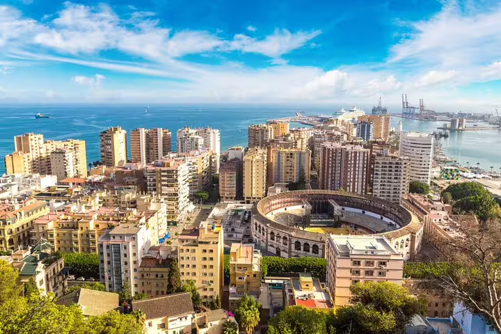 Aerial view of Málaga city center with bullring, historic buildings, and Mediterranean port