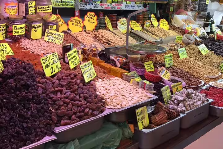 Vibrant Malaga market stall showcasing a variety of nuts and dried fruits, ideal for a culinary tour stop.