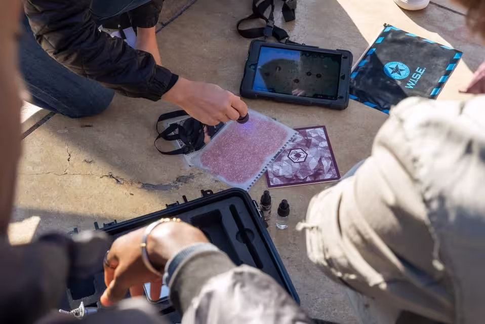 Team collaborating on a clue with gadgets in Malaga's Operation Mindfall outdoor escape adventure.