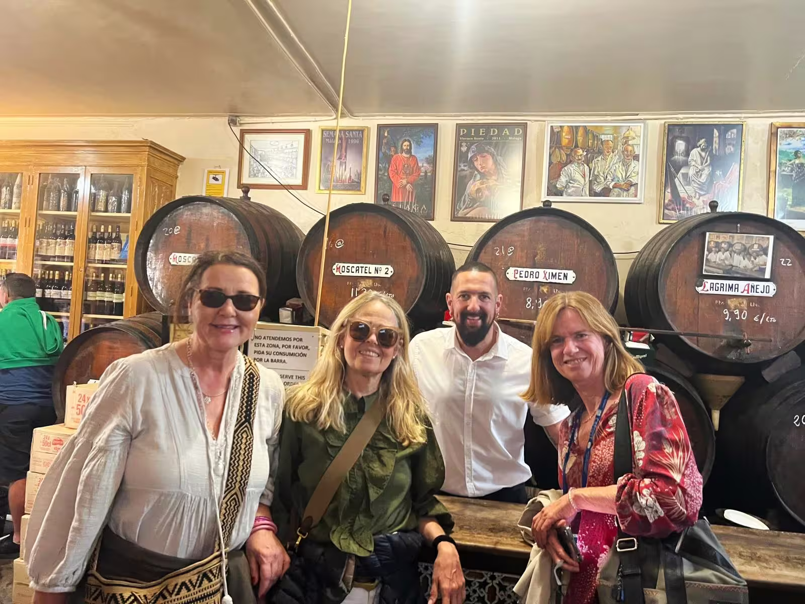 Guests enjoy Malaga private full day tour wine tasting at traditional bodega with oak barrels and guide