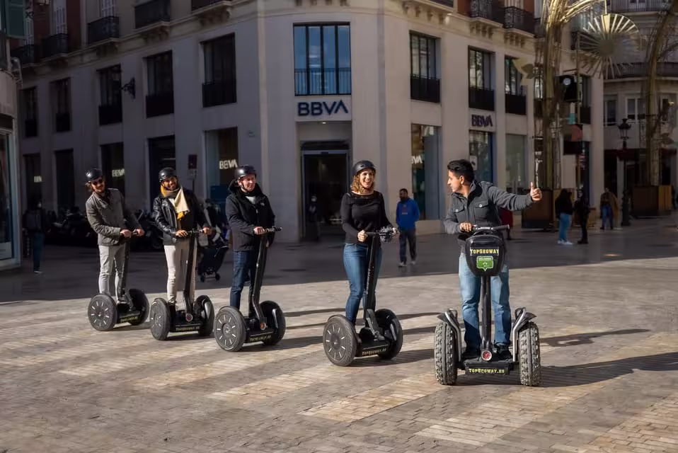 Group enjoying a Segway ride through Malaga's vibrant city streets on a panoramic tour.