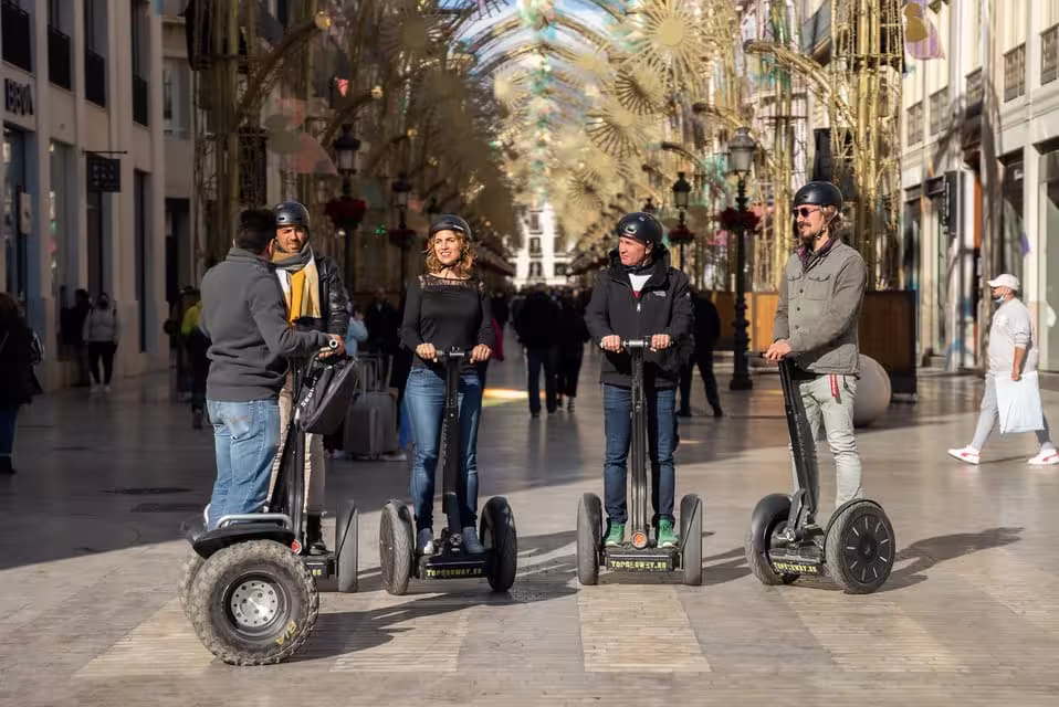 Participants on Segways admire the festive decorations in Malaga's bustling shopping district.