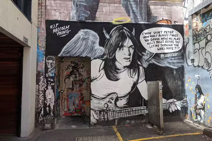 Street art mural of Malcolm Young as angel with guitar in Melbourne laneway