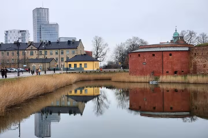 Scenic view of Malmö's modern and historic architecture reflected in a tranquil canal, perfect for sightseeing tours.