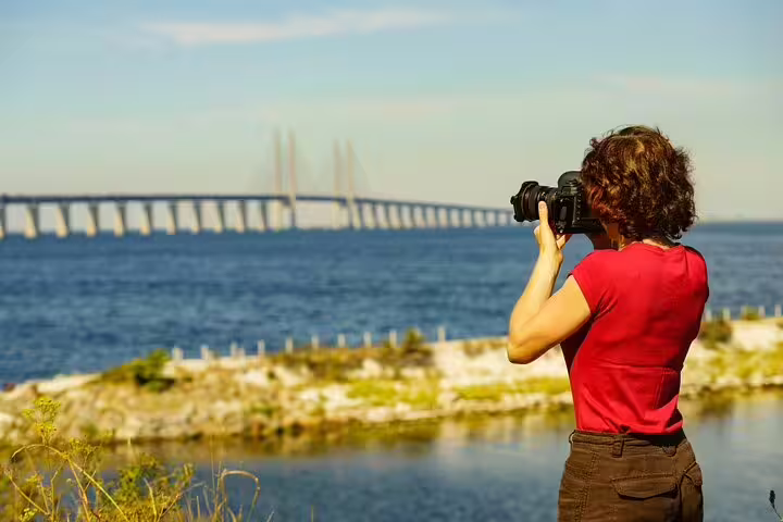 A tourist captures the scenic Öresund Bridge view during a Malmö private full-day trip from Copenhagen by train.