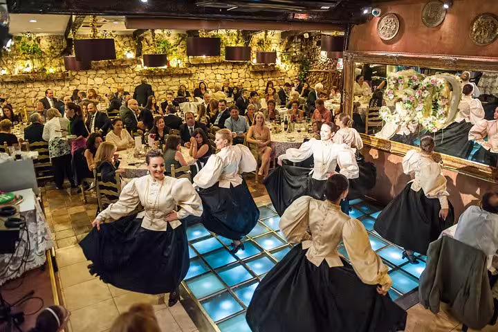 Traditional dancers in Maltese attire perform energetically during the Folklore Night Tour, enchanting a captivated audience.