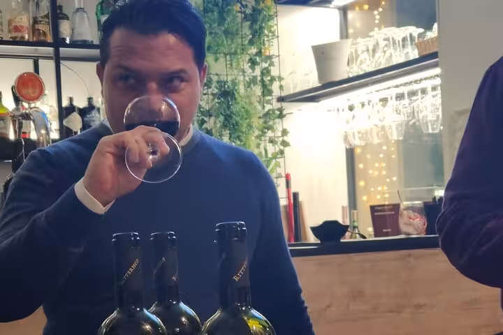 Man savoring red wine aroma during an immersive wine education session in Rome's elegant tasting room.