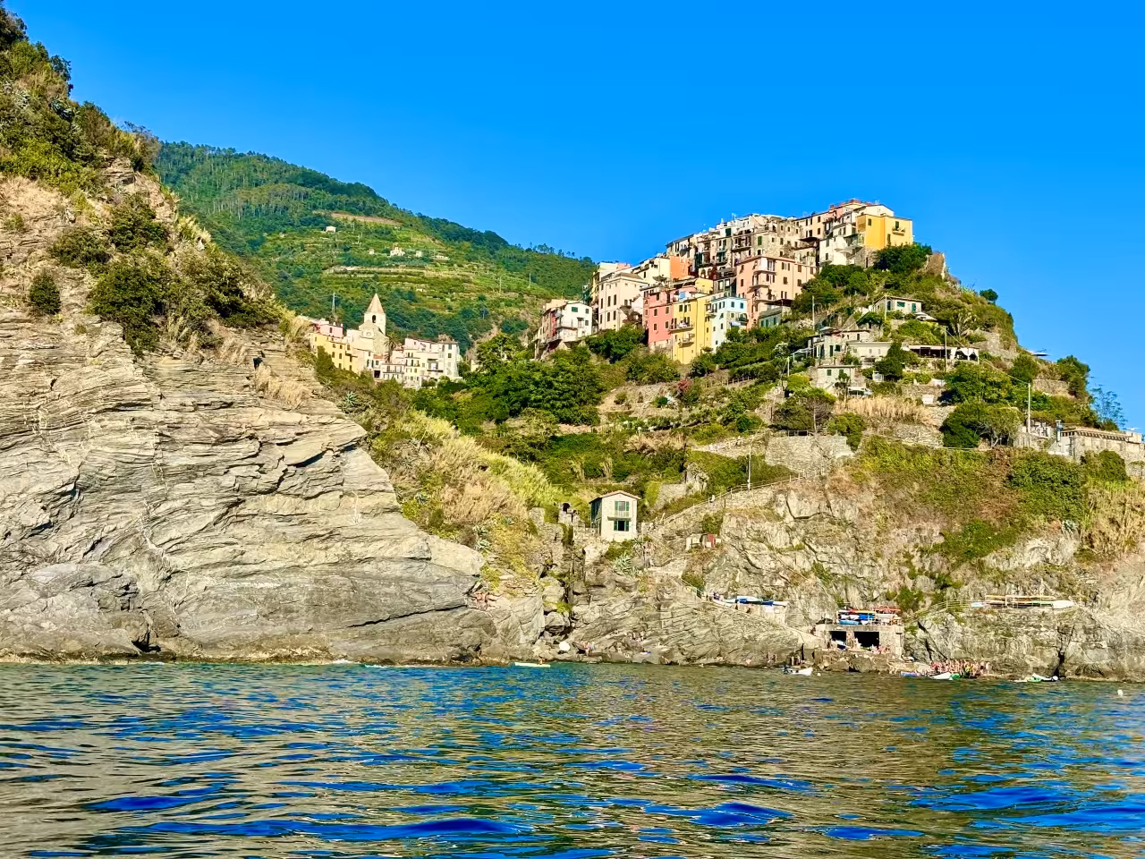 View of Manarola village cliffs and colorful houses from the sea on a Cinque Terre boat tour from La Spezia