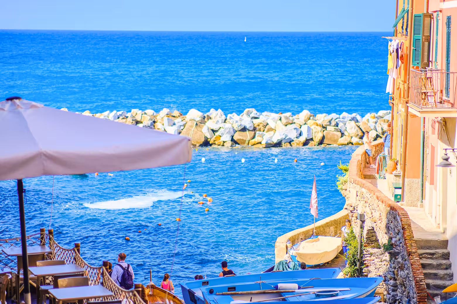Picturesque waterfront view in Manarola, Cinque Terre with colorful boats and charming seaside atmosphere.