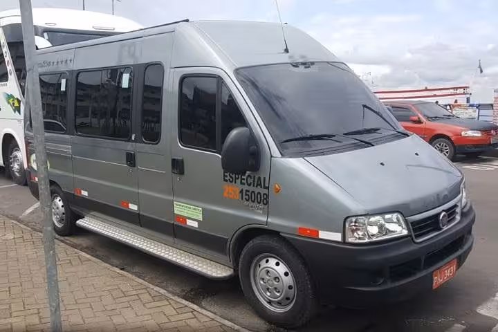 Manaus airport transfer minibus parked curbside, reliable shuttle service from MAO airport to any city address