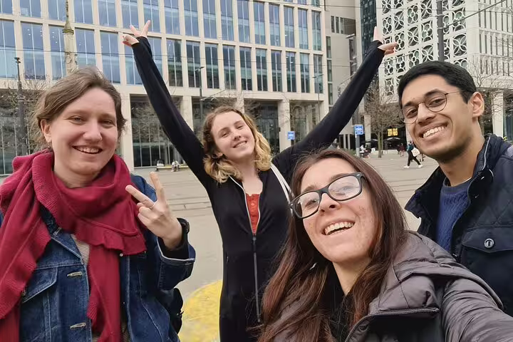 Four friends smiling and posing during a self-guided walking tour in Manchester city centre