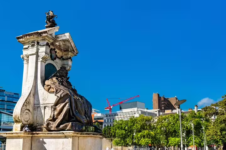 Historic stone monument with bronze sculpture in Manchester city square on a sunny day