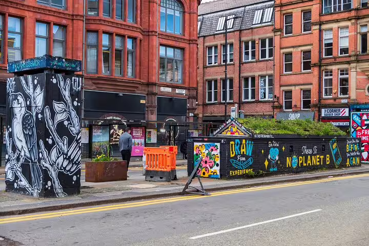 Manchester street art murals on brick buildings with 'No Planet B' graffiti wall and urban street scene