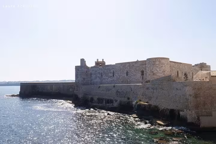 Explore the historic beauty of Maniace Castle in Syracuse, Sicily, overlooking the sparkling Ionian Sea.