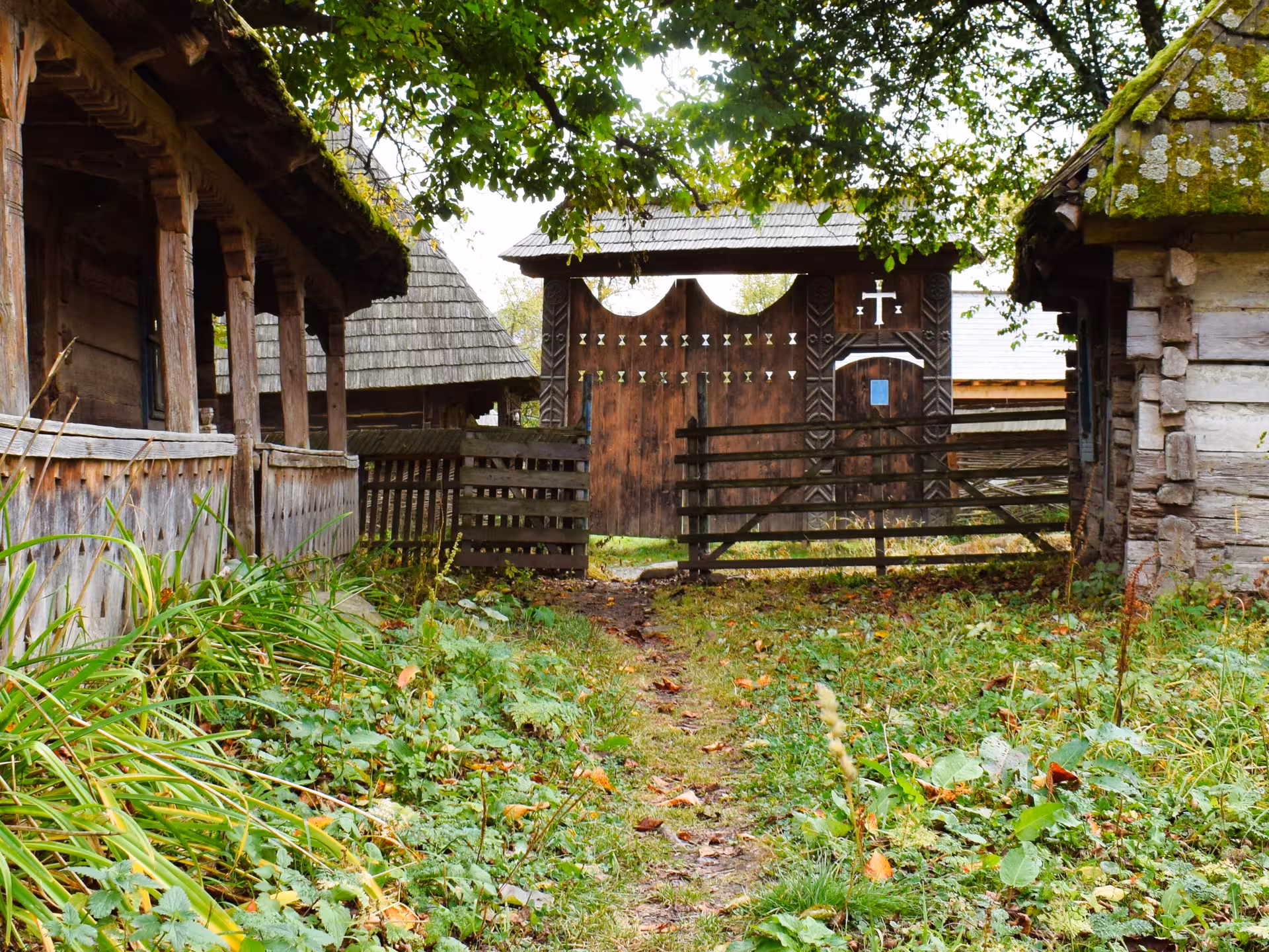 Traditional carved wooden gate with cross at a Maramures UNESCO heritage village in Romania