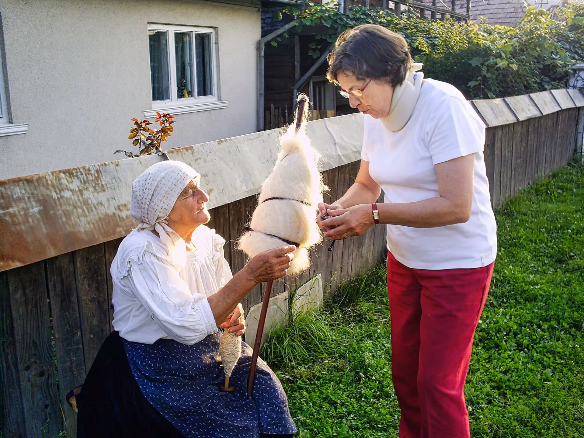 Local Maramures woman demonstrating traditional wool spinning to a tourist on a 3-day guided tour from Cluj