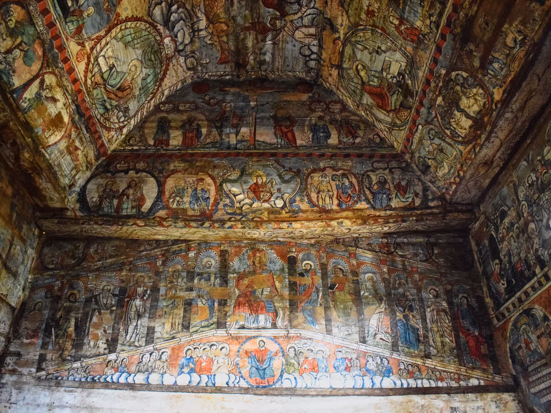 Vibrant interior frescoes covering walls and ceiling of a UNESCO wooden church in Maramures Romania