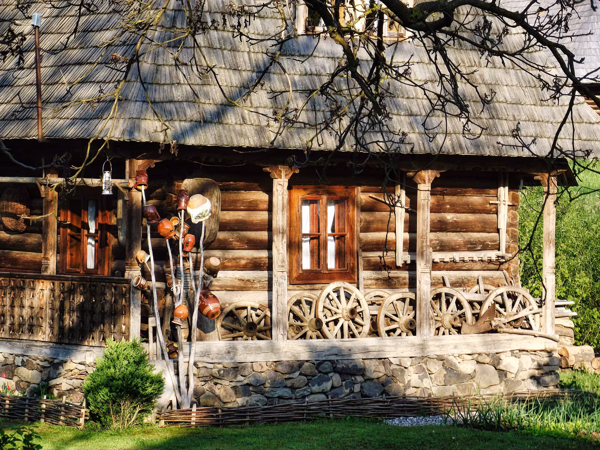 Traditional Maramures wooden farmhouse with ceramic pots and wagon wheels on a Romania rural village tour