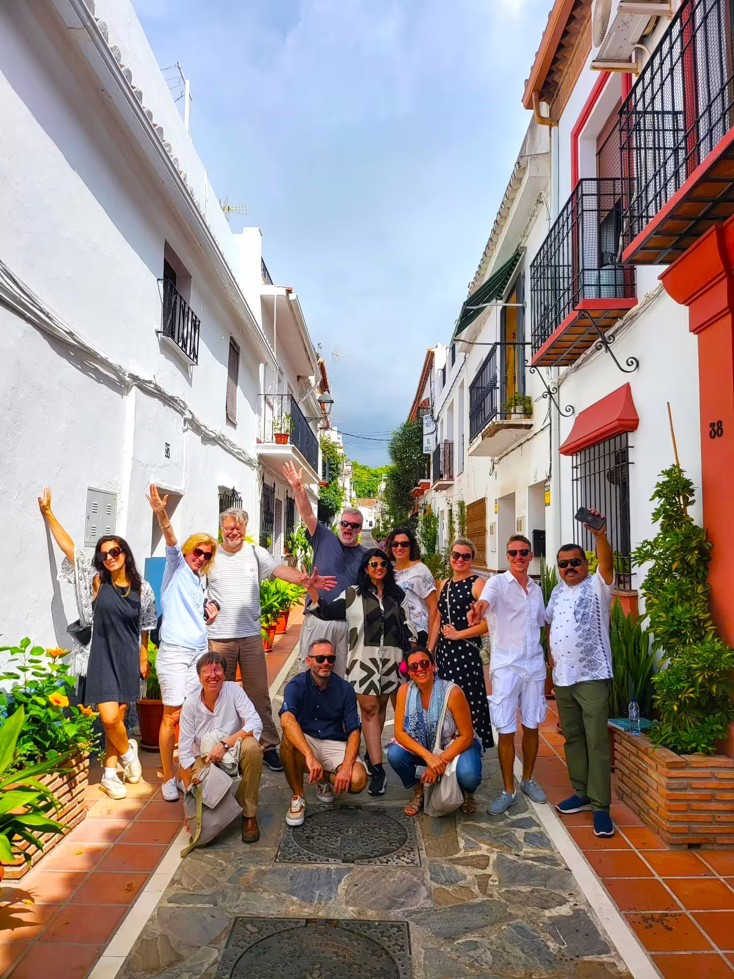 Private Marbella and Mijas full-day tour group photo in Mijas Pueblo whitewashed street with balconies