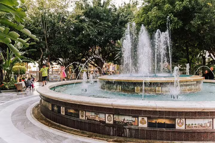 Beautiful fountain surrounded by lush greenery in Marbella Old Town, perfect for a relaxing stop on a walking tour.